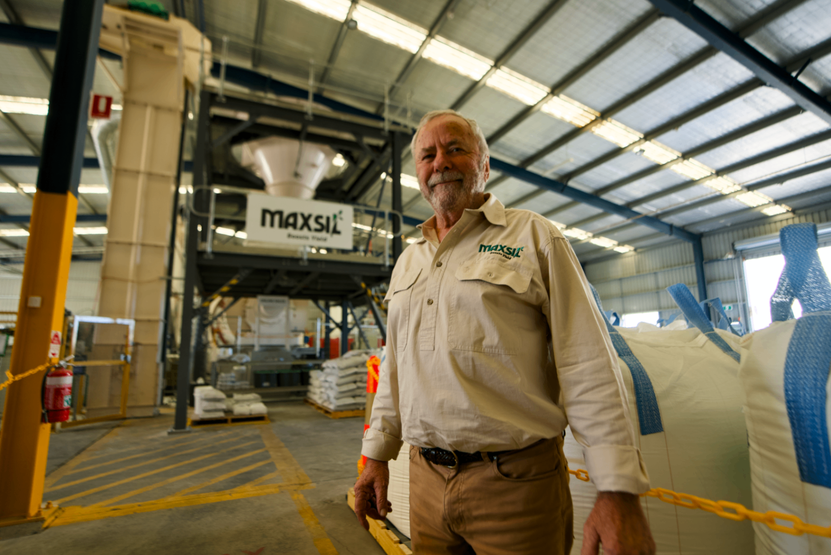 A worker standing in the Brendale processing shed with the milling plant behind him